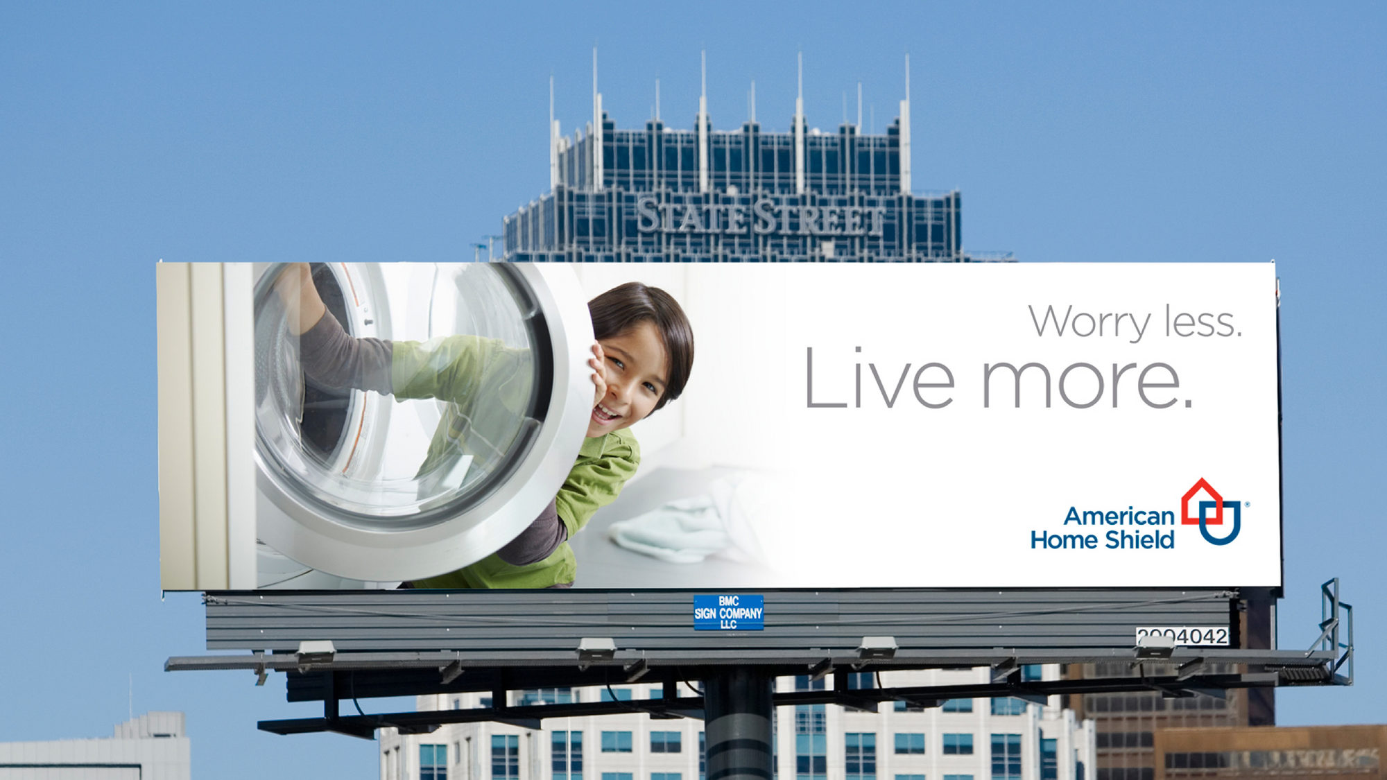 American Home Shield billboard design with child opening washer, logo and text - Worry less. Live more.