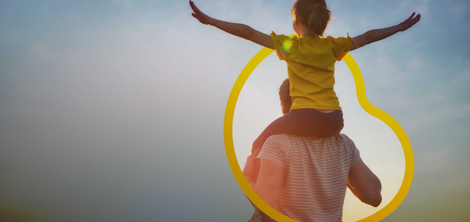 A man standing outside with child on shoulders within Goldfinch bio logo