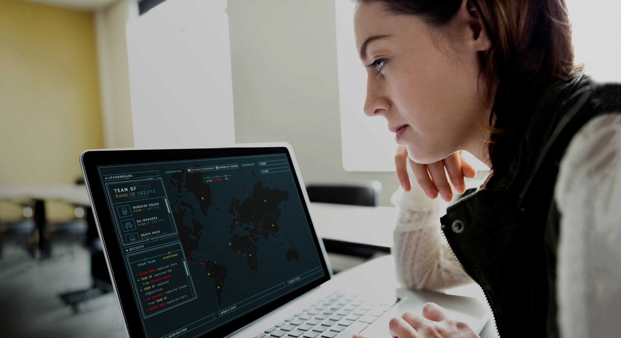 Facebook game hero image, woman playing capture the flag digital game on her laptop