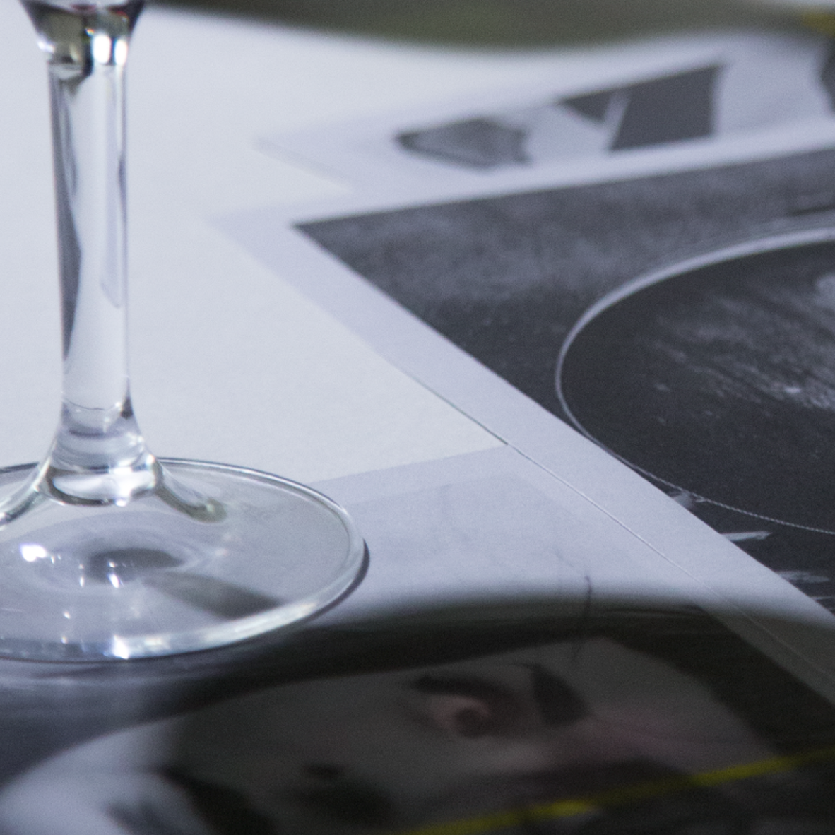 Wine glass sitting on photographs